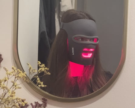 The writer in a mirror wearing the Flikeze mask which is black and glows red.