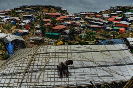 A Rohingya refugee uses bamboo to fix his roof during the monsoon season at Balukhali refugee camp, neighbouring the Kutupalong site, in Cox’s Bazar, Bangladesh