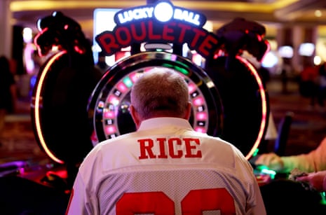 A man wearing a football jersey gambles in a casino