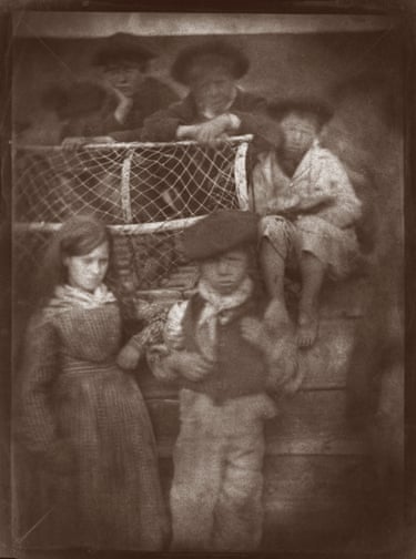 Newhaven children on an upturned boat with a lobster pot, modern print from calotype negativeThe fishing series of some 120 to 130 photographs was designed in response to the whole community, including the restless children and infants in arms. This image has failed in the photographers’ terms, but shows the intelligent construction of the picture to provide support for the children, using the familiar materials of the lobster pot and the boat to give them confidence.