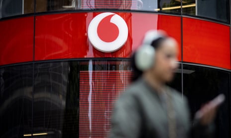 A person wearing headphones walk past a Vodafone shop on Oxford Street in London, Britain, 16 May 2023.