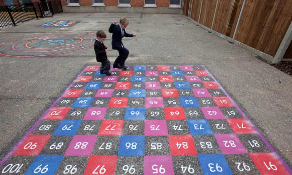Children playing on a numbered grid in school