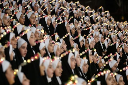 Rows of Iraqi girls who have reached the age of puberty wear Islamic dress for the first time.