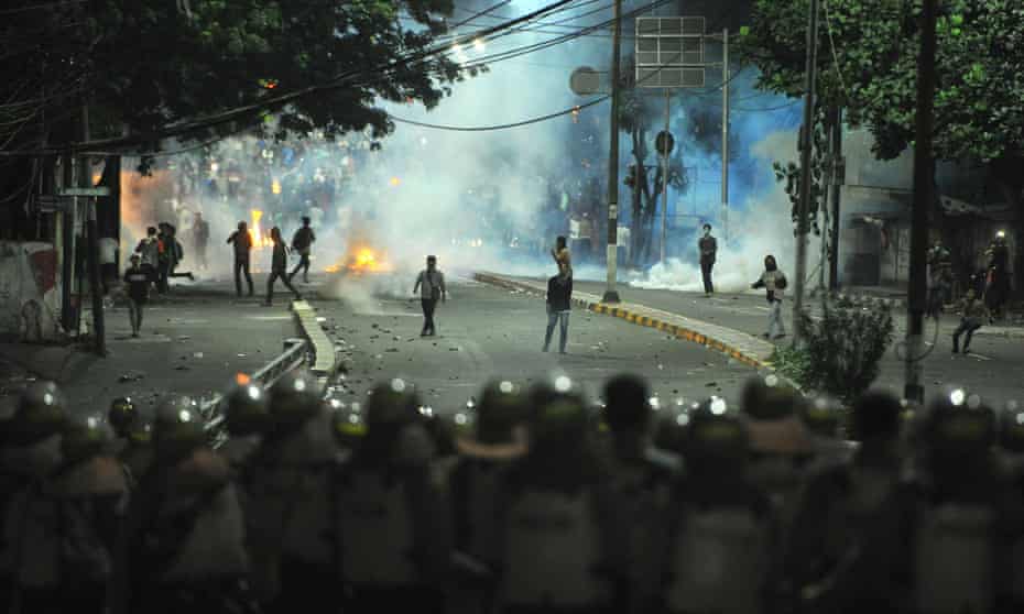 Indonesian riot police officers are seen during a clash in front of the Election Supervisory Agency in Jakarta