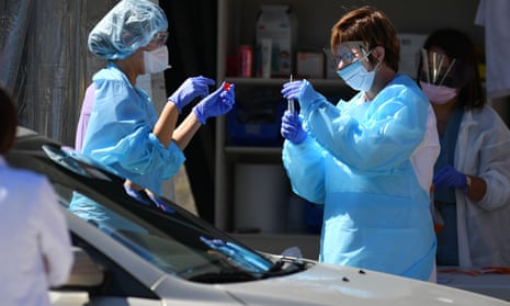 Medical workers at Kaiser Permanente test a patient for coronavirus at a drive-thru testing facility in San Francisco on Wednesday.