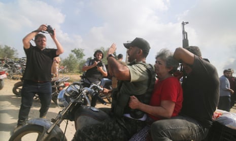 Palestinians transport a captured Israeli civilian from Kibbutz Kfar Azza into the Gaza Strip on 7 October.