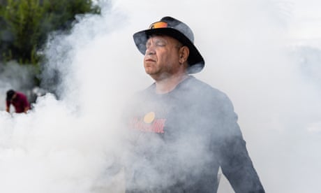 A First Nations man is surrounded by smoke