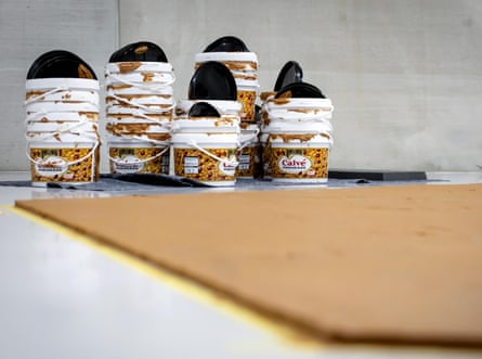About 15 large empty tubs of peanut butter next to the installation