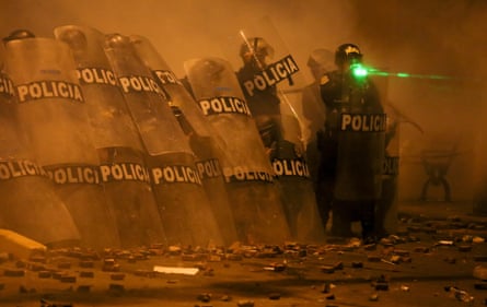 Riot police take cover after the ‘Take over Lima’ march on Thursday night.