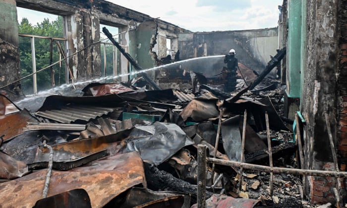 A firefighter extinguishes a blaze at a school in the Ukrainian city of Kharkiv after a missile strike