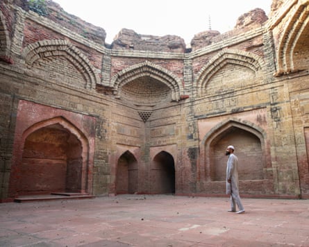 A man walks through the ruined, arched courtyard of Sadna Qasai mosque in Fatehgarh Sahib