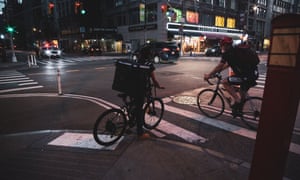 Delivery workers at night on 5th Ave during the coronavirus outbreak, in Manhattan.