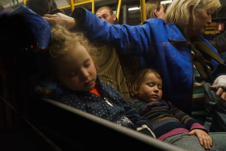 Children asleep on a bus as a convoy carrying evacuees from Mariupol and Melitopol arrives in Zaporizhzhia.