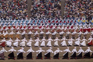 Rows of dancers in traditional outfits holding hands