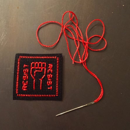 a black and red stitched square showing a fist