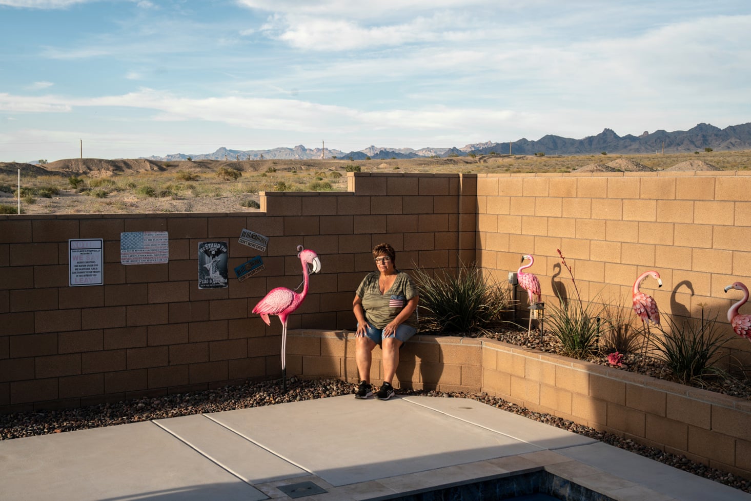 Woman sits outside next to a pink flamingo