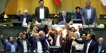 Iranian lawmakers burn two pieces of papers representing the US flag and the nuclear deal as they chant anti-American slogans at the parliament in Tehran, Iran, May 2018.