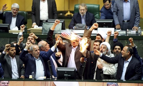 Iranian lawmakers burn two pieces of papers representing the US flag and the nuclear deal in the parliament in Tehran.