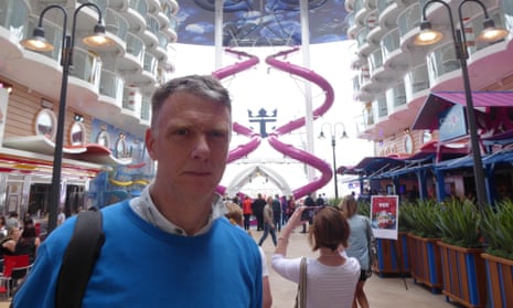 Sam Wollaston on board the Harmony of the Seas, with the purple Ultimate Abyss slide behind.
