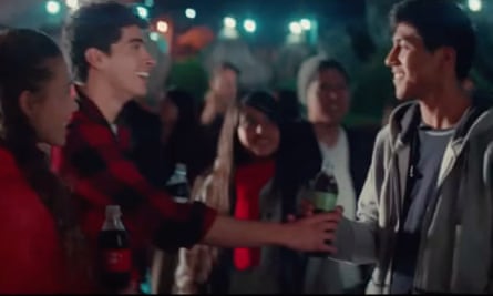A bottle of Coca-Cola is passed to an Indigenous man in Mexico.