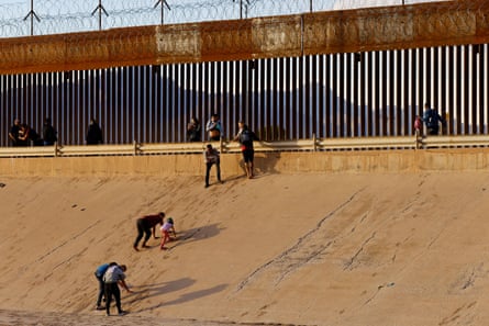Asylum-seeking migrants, mostly from Venezuela, walk out of the Rio Bravo river after crossing it to turn themselves in to US border patrol agents to request asylum in El Paso, Texas, as seen from Ciudad Juarez, Mexico, 6 October.
