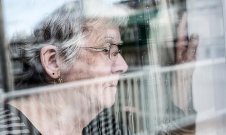 An older woman looking out of a window
