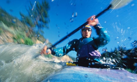 Close up, as water splashes the camera and waves swirl around, of someone doing whitewater kayaking in New Zealand