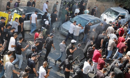 رجال يطلقون النار في الهواء أثناء تشييع الجنازة