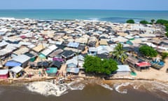 An aerial photo shows residents of Akwidaa fishing village in Ghana erecting a makeshift sea defence