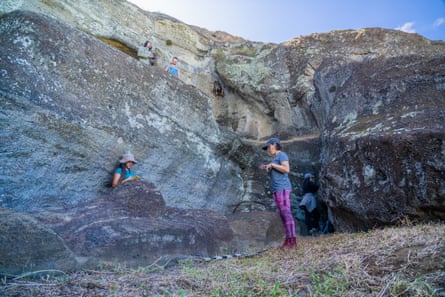 Four people stand amid rocks in what looks like a quarry