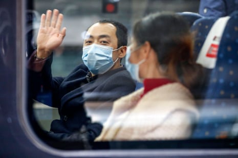 A man waves from the first outbound train leaving Hubei province since the lockdown was ended