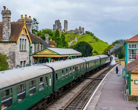 Corfe Castle railway station with an old steam train passing through in September