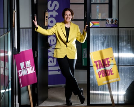 Kezia Dugdale stands with her hands resting against the jambs of a doorway with Stonewall placards and signage around
