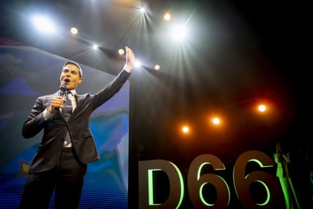 Rob Jetten raises a hand for acclaim on a stage branded D66