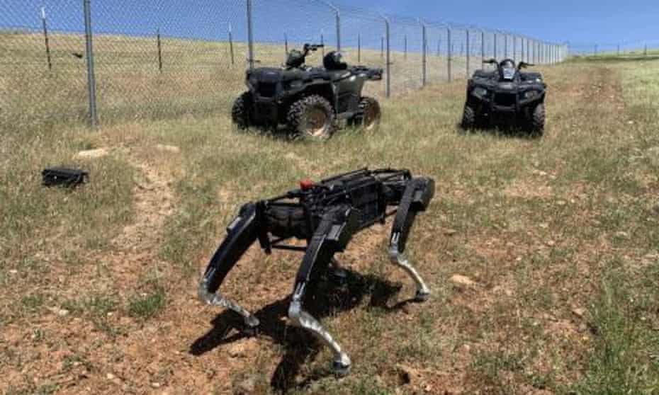 Robotic dog on grass next to fence