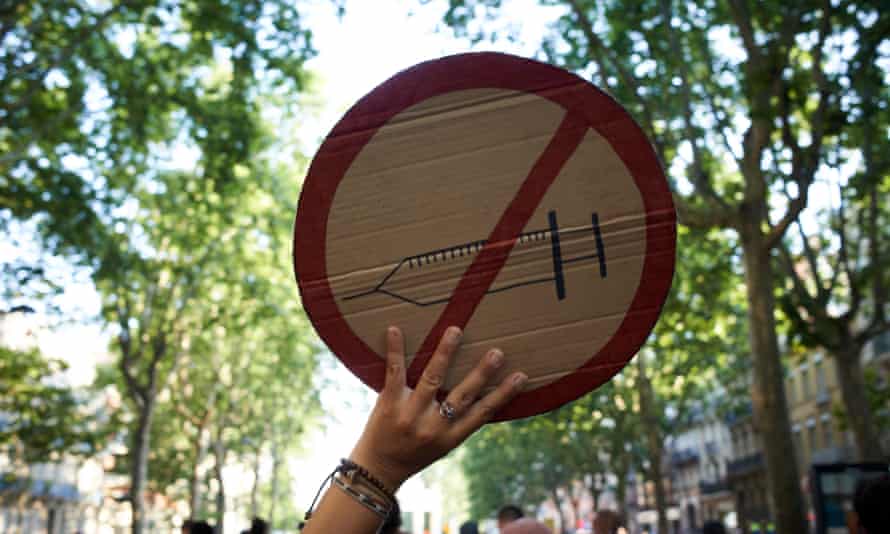 Protester holding a sign bearing a crossed-out syringe.