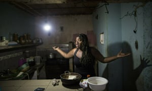 Dugleidi Salcedo complains to a neighbor about the high price of food as she prepares arepas for her three sons in her kitchen in the Petare slum, in Caracas, Venezuela, in February 2019.