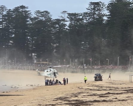 NSW Ambulance officers treat a shark attack victim at Manly beach in Sydney on Monday.
