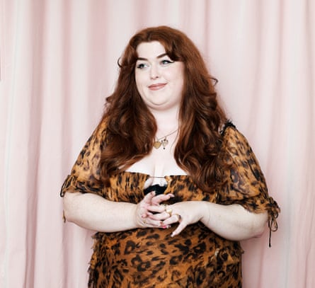 Ione Gamble wearing an animal print dress, a pale pink curtain behind