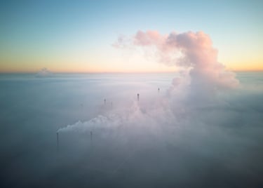 Smoke from factory rising above clouds