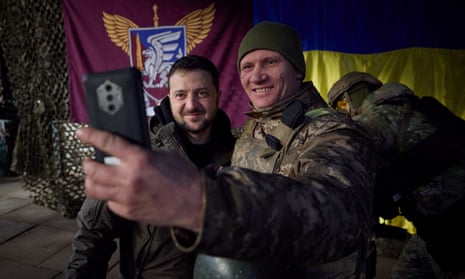 Ukraine's president, Volodymyr Zelenskiy, poses for a picture with a service member at a position near the frontline in the Donetsk region.