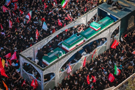Crowds seen from above around coffins