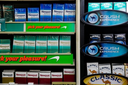 Newport and Camel cigarettes are stacked on a shelf inside a tobacco store in New York