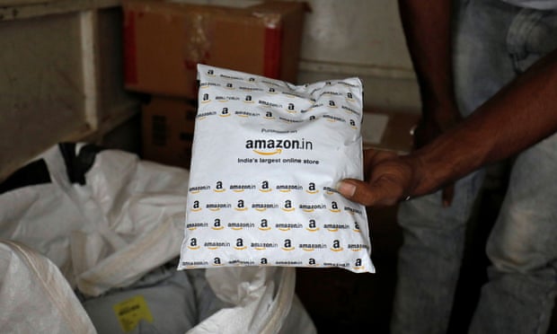 A worker sorts delivery packages in a van outside an Amazon facility in Ahmedabad, India, March 2021