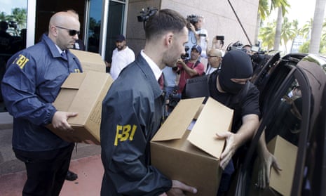 FBI agents bring out boxes after an operation inside the Concacaf