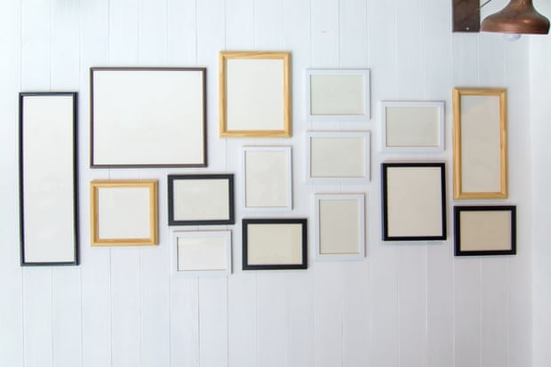Empty frames hang on  a white wall