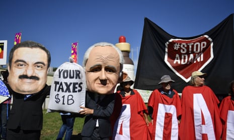 Protesters hold signs and banners at a Stop Adani Mine rally on the lawns of Parliament House in Canberra, Monday, February 5, 2018