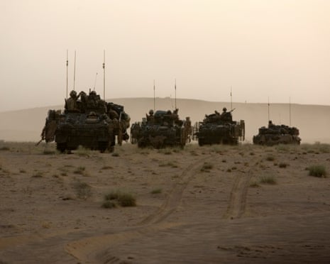 British troops in armoured personnel carriers at dusk in Afghanistan