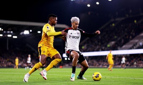 Fulham’s Antonee Robinson, right, is challenged by Wolves’ Nelson Semedo during the Premier League match at Craven Cottage on 27 November 2023 in London,