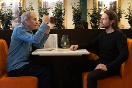 Philip and Carl chatting and eating at a restaurant table